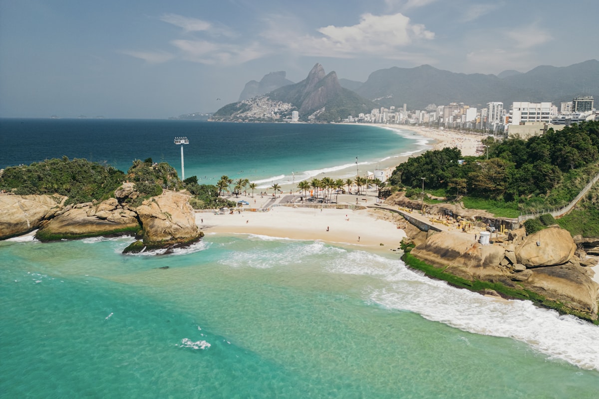 Praia com água azul e cidade ao fundo